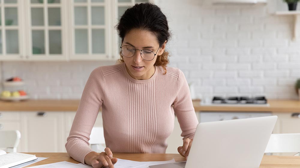 woman working on laptop and calculator going over tuition fees